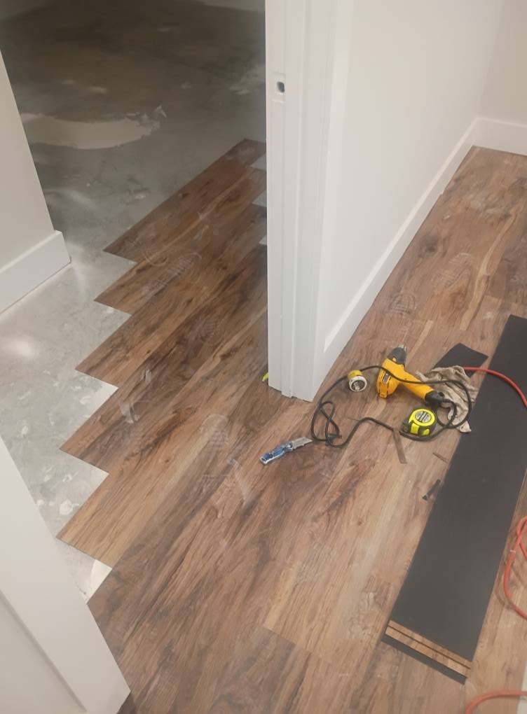Glue down vinyl plank flooring installation in progress